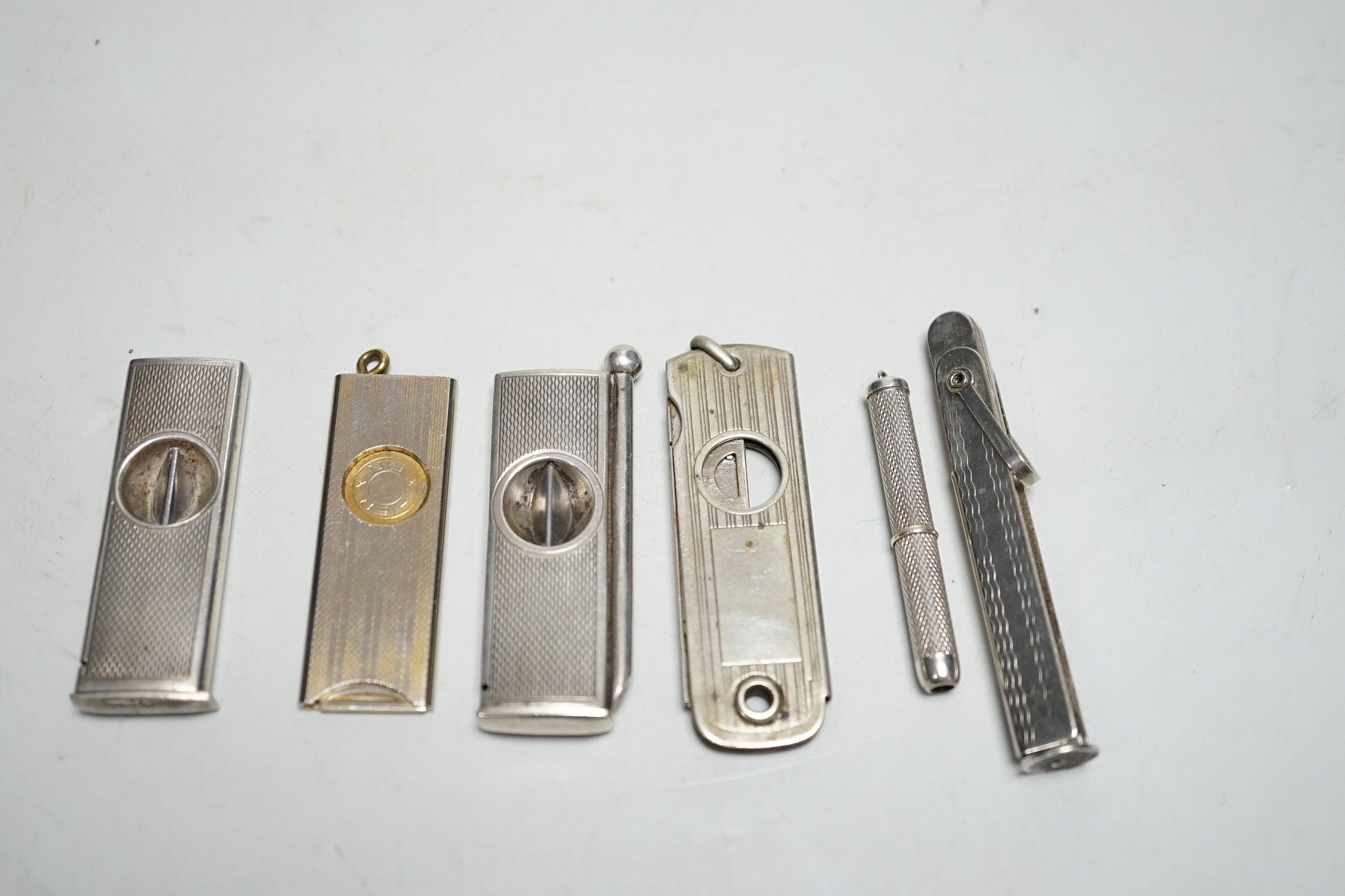 Two silver cigar cutters, a plated tamper and two other cutters / piercers